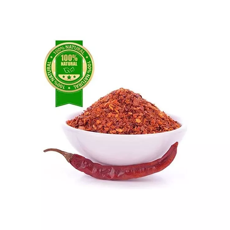 A white bowl filled with vibrant ground red Thai chilli flakes, paired with a fresh red chilli and a 100% natural label.