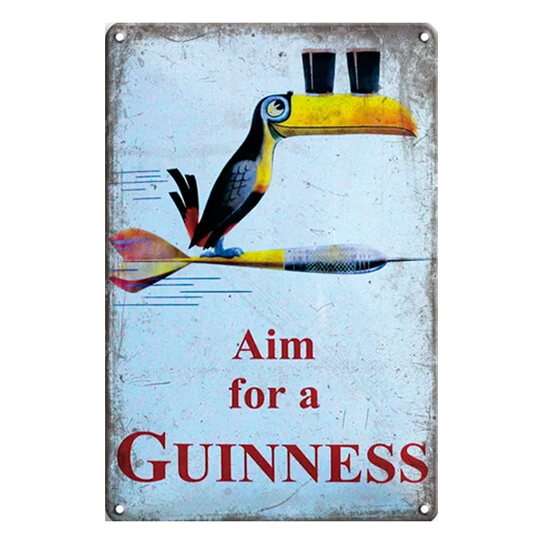 Retro metal sign featuring the Guinness toucan on a dart with two pints, accompanied by the slogan "Aim for a Guinness." Perfect for home bars